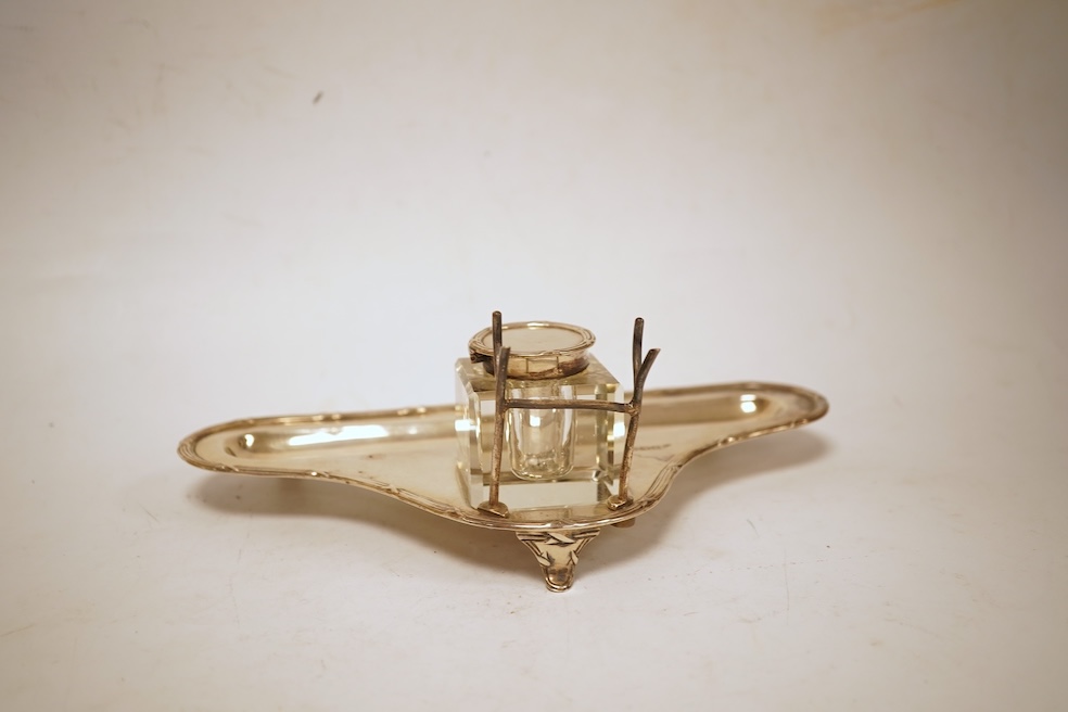 A George V silver inkstand, with single mounted glass well, pen rest and pen recess, with reeded ribbon border, William Hutton & Sons, Sheffield, 1913, 23.9cm, 5.2oz.